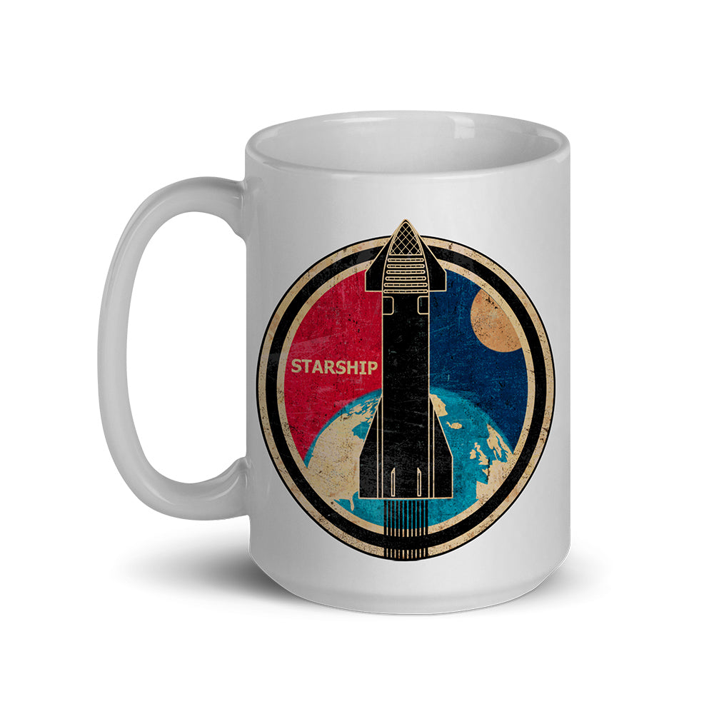 A white ceramic mug featuring a circular graphic of a black Starship rocket launching over a blue Earth and beige moon, with a red sky section and the word 'STARSHIP' on the front.